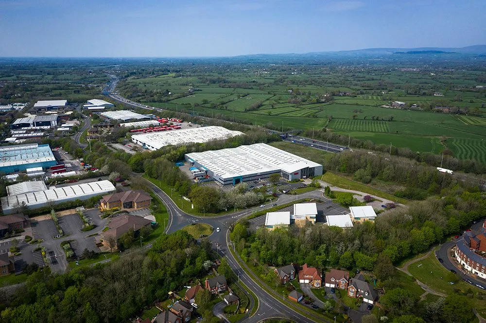 Aerial view of industrial warehouses beside a motorway