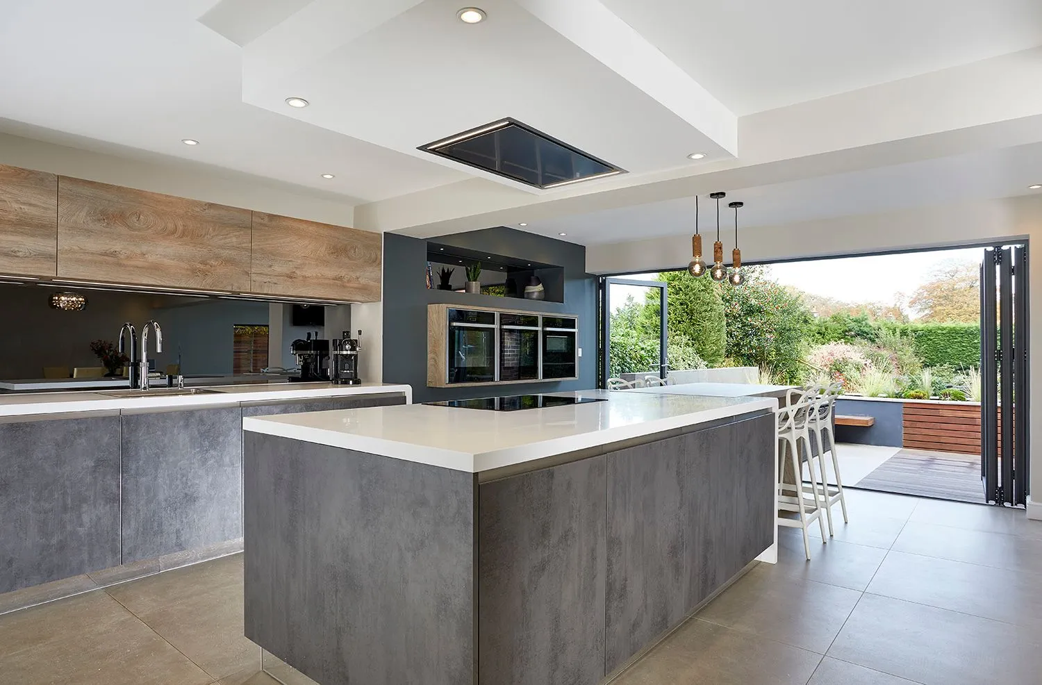 Kitchen with a concrete-effect island and bi-fold doors to the garden