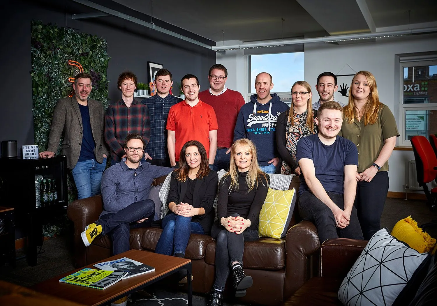 Creative team gathered around leather sofas in a creative office
