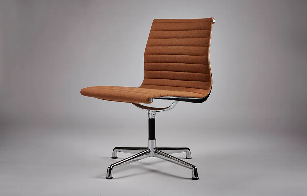 Aluminium-framed chair with tan ribbed upholstery on a grey backdrop