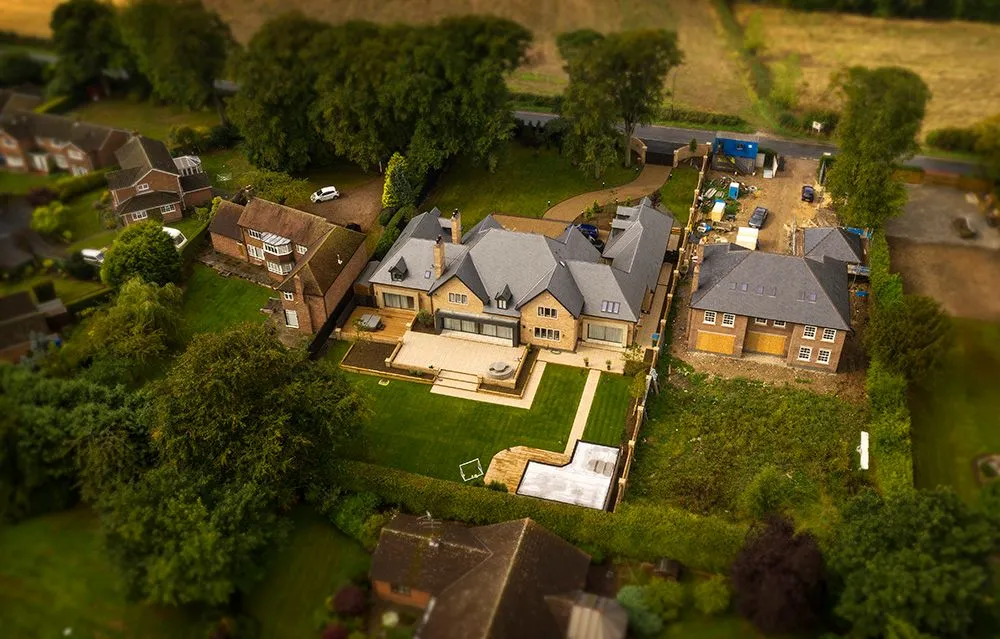 Aerial view of detached new-build homes surrounded by trees