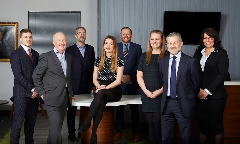 Leadership team standing together in a bright office
