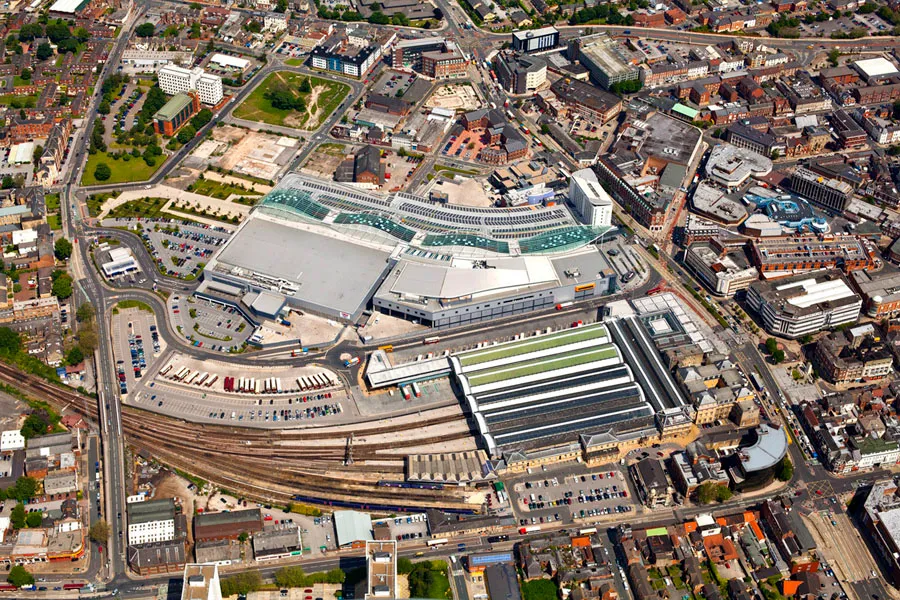 Aerial view over a northern town centre, railway station and retail park