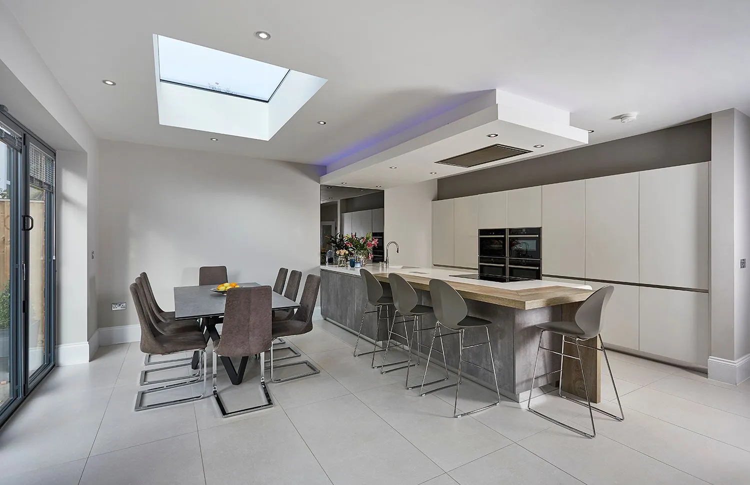 Kitchen with a roof lantern, island and dining table