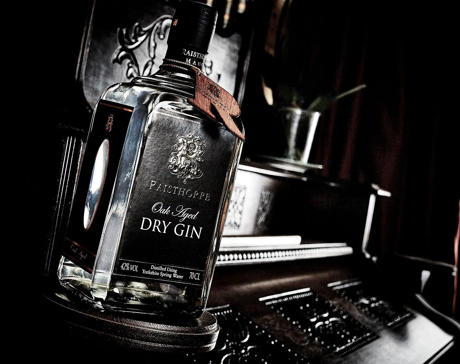 Bottle of oak-aged dry gin in low, moody light