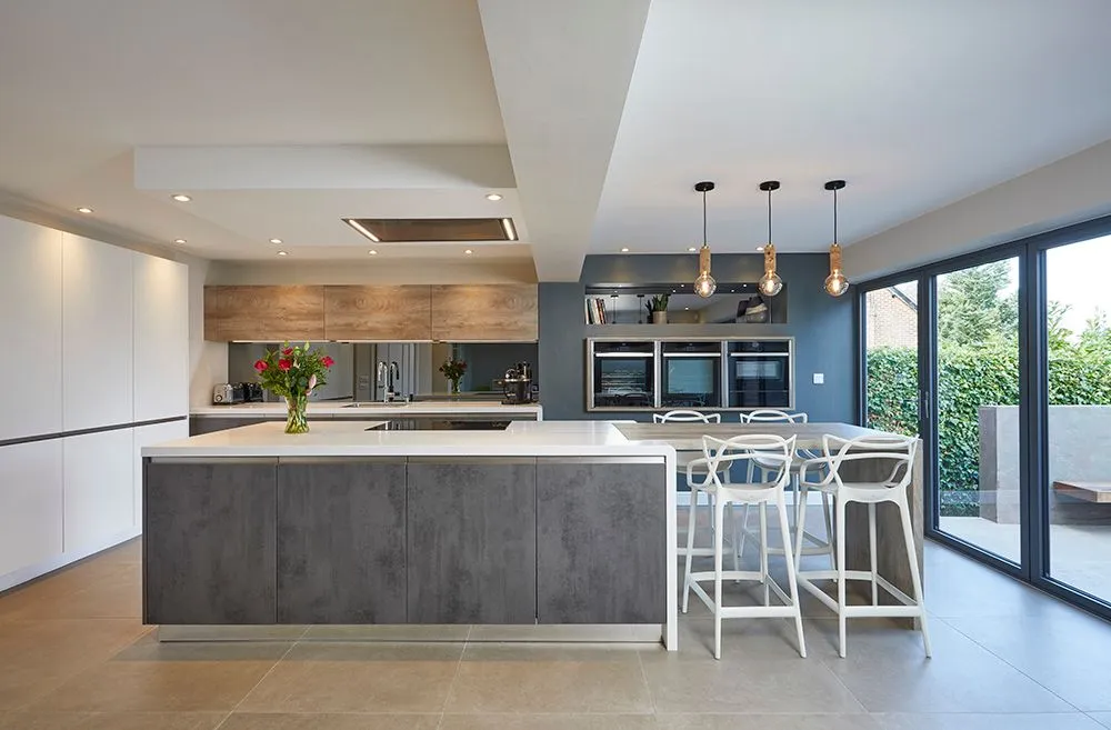 Modern kitchen with a concrete-effect island, pendant lights and bi-fold doors