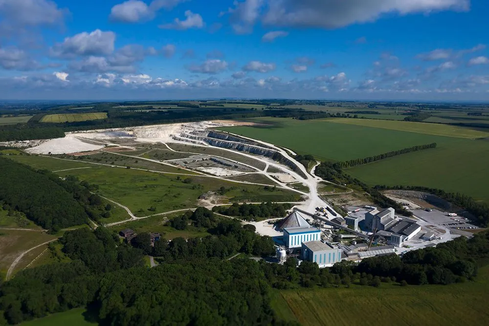 Aerial view of a working quarry surrounded by green countryside