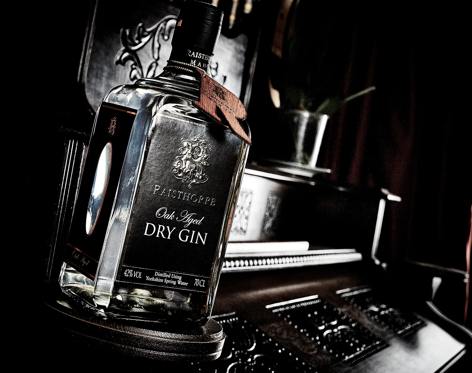 Bottle of oak-aged gin in low, moody light